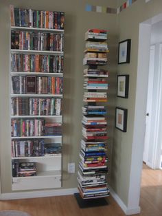 a tall bookcase filled with lots of books in a living room next to a doorway