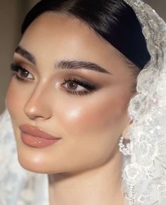 a woman wearing a veil and makeup looks off to the side with her eyes closed