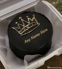 a black cake with a gold crown on top in a white box that says any name here