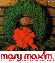 a christmas wreath with a red bow on it and the words mary maxm exclusively needlework and crafts