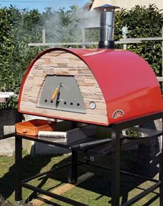 an outdoor pizza oven sitting on top of a table