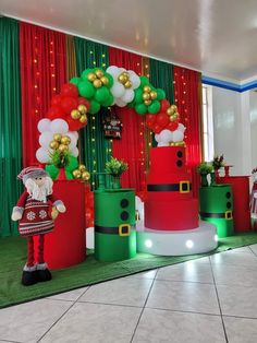 christmas decorations are on display in front of red, green and white balloons with santa clause standing next to them