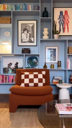 a living room filled with lots of furniture and bookshelves covered in pictures on the walls