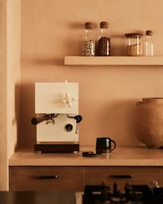 an espresso machine sitting on top of a counter next to a coffee pot