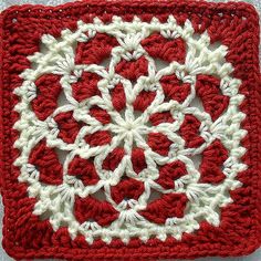 a red and white crocheted square with snowflakes on it