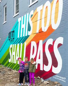 two children standing in front of a colorful wall