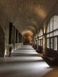 a long hallway with lots of windows and benches next to each other on either side