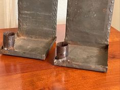 two metal bookends sitting on top of a wooden table