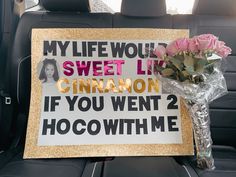 a bouquet of flowers sitting on the back seat of a car next to a sign that says, my life would sweet live cinnamon if you went? hocowith me