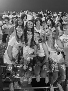 a group of young women sitting next to each other on top of a bleachers