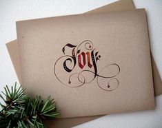 two greeting cards with the word joy written in cursive writing on them next to a pine branch