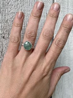 A stunning light green raw sapphire has been set in sterling silver with a handmade ring band from a uniquely patterned sterling silver rounded edge wire. This sapphire stone is just breathtaking with its light green hue and gray stripe running through the center. The faceted cut of the sapphire helps the gemstone catch the light and truly sparkle. The stone sits in a serrated setting. It is 13mm x 12mm at the widest points in size.Size 7, cannot be sized up or down. Sterling Silver Sapphire Ring With Natural Stones For Anniversary, Anniversary Sapphire Ring With Natural Stones In Sterling Silver, Anniversary Sterling Silver Sapphire Ring With Natural Stones, Faceted Sapphire Ring Jewelry, Faceted Tourmaline Ring Gift, Sterling Silver Emerald Ring With Natural Stones For Anniversary, Silver Sapphire Emerald Ring With Gemstone, Faceted Silver Emerald Ring As Gift, Silver Faceted Emerald Ring For Gift