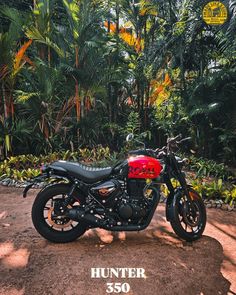 a motorcycle is parked in the dirt near some trees and bushes with an advertisement for hunter 350