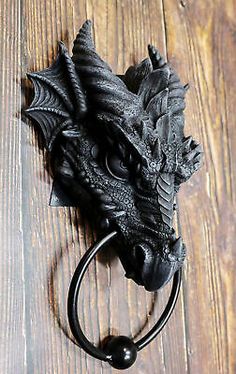 a black dragon door handle on a wooden floor