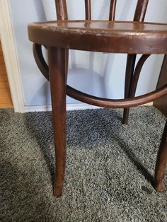 a wooden chair sitting on top of a carpeted floor