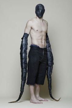 a shirtless man with an arm and leg armor