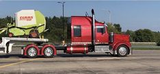 a red semi truck parked in a parking lot