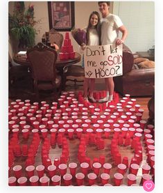 two people standing next to each other with cups in front of them and a sign that says don't let me go solo