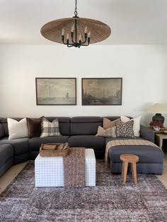 a living room filled with lots of furniture next to a wall mounted painting on the wall