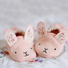 two pink stuffed animals sitting on top of a bed