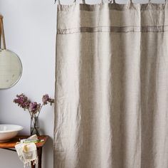 a bathroom with a sink, mirror and shower curtain that is made out of linen