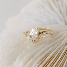 a white diamond ring sitting on top of a piece of paper