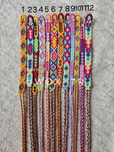 six different colored bracelets with tassels hanging from the ends and on each side