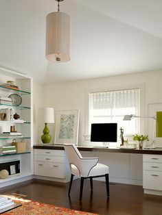 a white chair sitting in front of a computer monitor on top of a wooden desk