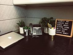 a desk with a laptop, phone and other office supplies