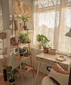 a living room filled with lots of plants next to a white desk and window sill