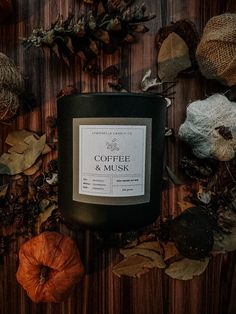 a candle sitting on top of a wooden table surrounded by leaves and acorns