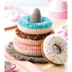 a stack of knitted donuts sitting on top of a table next to a cup