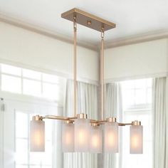 a chandelier with five lights hanging from the ceiling in a living room or dining room