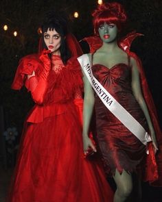 two women dressed in red and green make up for the miss america pageant, one holding a sash