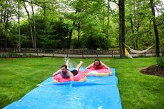 two women laying on inflatable mattresses in the grass