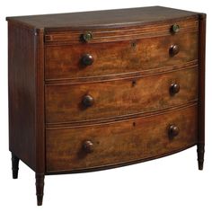 an old chest of drawers with knobs on the top and bottom, in dark wood