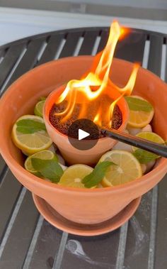 an orange bowl filled with lemons and fire