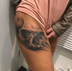 a woman with a skull tattoo on her thigh