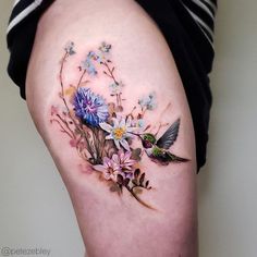 a woman's thigh with flowers and birds on it