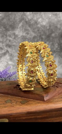 Temple bangle in matte gold and ruby stone. Detailing has the Rajasthani similarity. Comes in a pair . Can be bought in pair as well. About half an inch think. Luxury Multicolor Temple Jewelry Chandbalis, Luxury Gold Temple Jewelry Bangle, Yellow Gold Round Temple Jewelry Bangle, Multicolor Intricate Temple Jewelry Bangle, Temple Jewelry Brass Bangle With Intricate Design, Dual-tone Temple Jewelry In Brass, Ruby Stone, Matte Gold, Earring Necklace