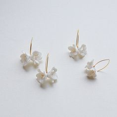 Each earring is exquisitely made by hand, featuring two delicate white clay flowers adorned with freshwater pearls. Skillfully handcrafted, these flower bridal earrings are the perfect complement to our signature porcelain headpieces.  These earrings are extremely lightweight. They are very elegant in their simplicity and have a very versatile design that would match many different wedding dress styles. ITEM SPECIFICATIONS ♥Flower Size about : 0.4*0.4in  0.6*0.6in ♥The earrings are available in Adjustable White Jewelry With Flower Decoration, White Hoop Earrings For Celebration, Elegant White Hoop Earrings For Celebration, White Flower Earrings For Celebration, Elegant White Flower Hoop Earrings, Delicate White Hoop Earrings For Wedding, Flower-shaped White Jewelry For Wedding, White Flower Jewelry For Wedding, Elegant White Flower Earrings For Celebration