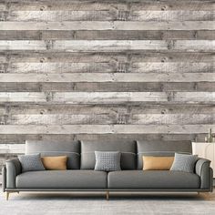 a couch sitting in front of a wall with wooden planks on it's sides