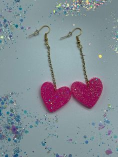 "LOVE! Bright Pink Glittery Hearts w/ Drop Chain! Made from resin, pink dye, medium silver glitter and fine white glitter with gold chain, gold split rings and gold fish hook findings.  Earrings measure 3 1/2\" inch in drop length by about a 1\" inch in width." Cute Heart Charm Party Jewelry, Cute Party Jewelry With Heart Charm, Cute Heart Charm Jewelry For Parties, Heart-shaped Jewelry With Lobster Clasp For Parties, Cute Heart Shaped Jewelry For Parties, Cute Heart-shaped Jewelry For Party, Cute Heart-shaped Party Jewelry, Pink Dangle Heart Earrings For Party, Pink Glitter Heart Earrings For Party