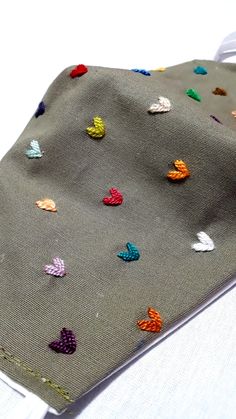 a close up of a tie on a white cloth with multicolored butterflies all over it