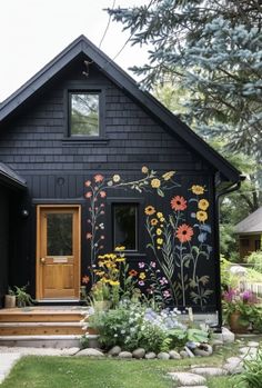 a black house with flowers painted on the side