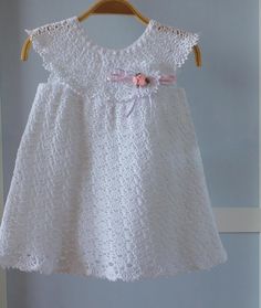 a white dress hanging on a wooden hanger