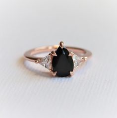 an image of a black diamond ring on a white surface with the top half cut off