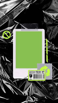 a tablet computer sitting on top of a pile of tinfoil next to a green sticker