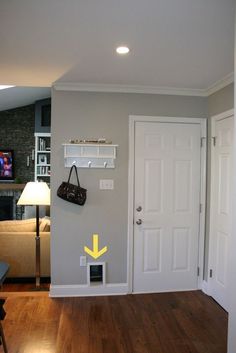 a living room with hard wood flooring and white trim on the walls, along with an open door