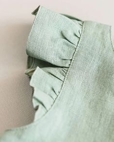 the back of a green shirt with ruffles on it